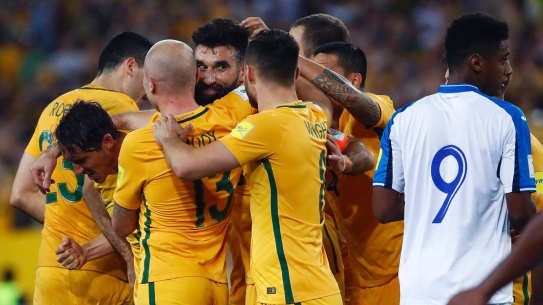 Job done: Mile Jedinak is mobbed after scoring.
