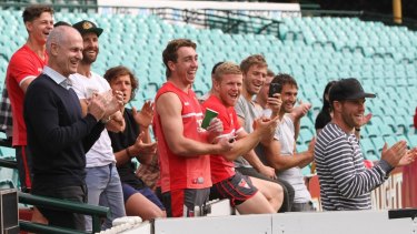 Sydney Swans players and coaching staff give Alex Johnson a standing ovation as he completes his lap.