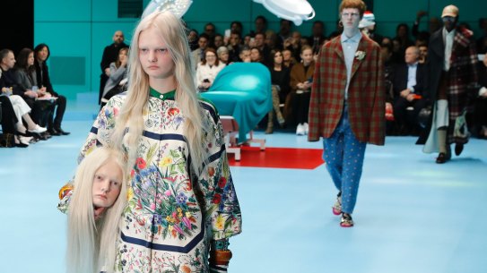 A model carries a fake head as she wears a creation as part of the Gucci women's Fall/Winter 2018-2019 collection, presented during the Milan Fashion Week, in Milan, Italy, Wednesday, Feb. 21, 2018.