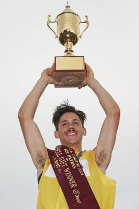 Matthew Rizzo raises the Stawell Gift trophy after his impressive win. 
