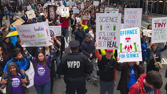 Demonstrators pass a policeman in the March for Science in New York last week.