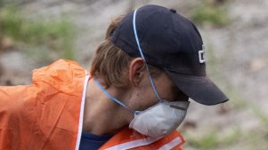 A worker removes mulch at Rozelle Parklands, which is closed after the discovery of asbestos at multiple locations.