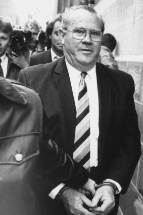 Rex "Buckets" Jackson, the former prisons minister, is led into court in handcuffs in 1987.