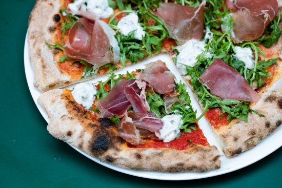 Downtown pizza with tomato, fior di latte, prosciutto, truffled stracciatella and rocket.