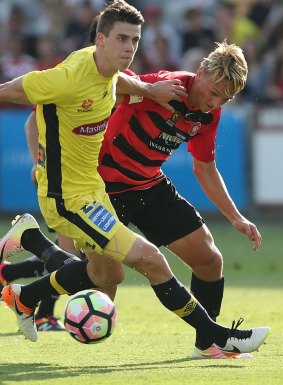 Jake McGing of the Mariners contests the ball with young Wanderer Lachlan Scott during an A-League clash at Central Coast Stadium.