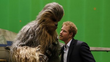 Rrrrrrrrrrrrr ... Prince Harry listens to some kinds words from Chewbacca during a tour of the <i>Star Wars</i> sets at Pinewood studios.