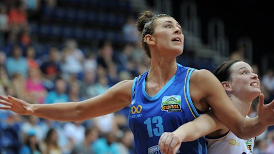Sport. WNBL match at the AIS Arena between the Canberra Capitals (blue) and the Melbourne Boomers. Caps centre, Alex Bunton, looks for the pass against Tess Madgen. January 25th. 2014 Canberra Times photograph by Graham Tidy.