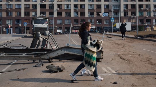 KYIV, UKRAINE - MARCH 23: A woman walks past a residential area which got damaged by rocket strike on March 23, 2022 in Kyiv, Ukraine. The rocket hit the shopping mall nearby on March 20, 2022. As Russia's advance on Kyiv has largely stalled, the Ukrainian capital has continued to be hit by missiles and shellfire. More than three million people have fled Ukraine since Russia launched its large-scale invasion of the country on Feb. 24. (Photo by Anastasia Vlasova/Getty Images)