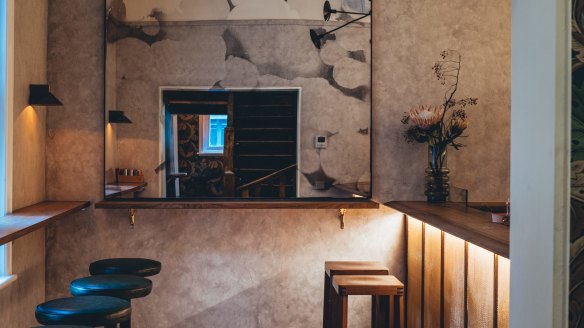 The space features ledges for leaning, soft grey marble-look walls, and two pairs of Tasmanian-made speakers.