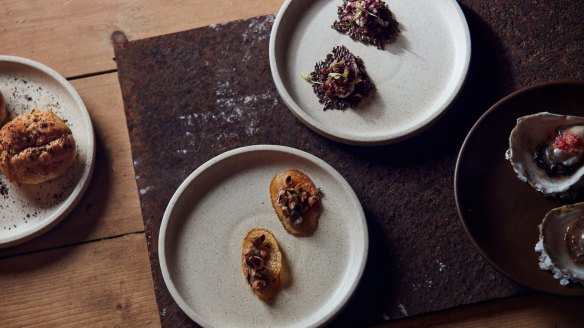 Opening snacks might include cheesy gougere with mountain pepper (left) and angasi oyster with finger lime (right).