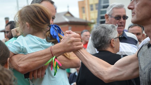 Abuse victim Peter Blekniron holds his daughter while shaking the hand of fellow survivor Tim Lane before he leaves Ballarat.