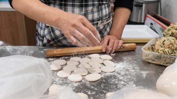 Wonton wrappers being rolled and filled by hand at Blissful Station.