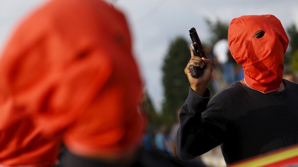 An armed man escorts others carrying the coffins of the victims of Monday's bomb attack in Suruc, during a funeral ceremony in Istanbul, Turkey on Wednesday.