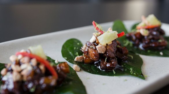 Betel bites of caramelised pork belly, betel leaf, cashew nuts, chili and lime.