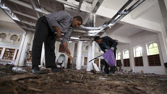 Crime scene investigators search for evidence on the floor after a suicide bomb attack at a mosque in Sanaa.