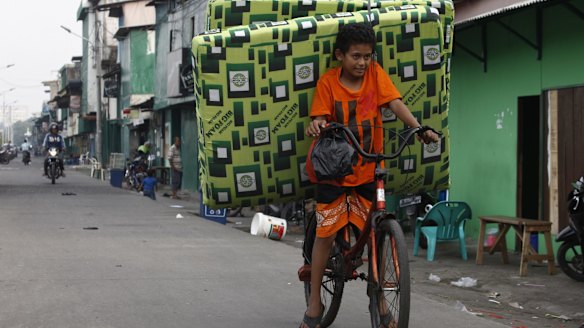 Testing times - Kelvin, a Kalijodo resident, helps his family move.