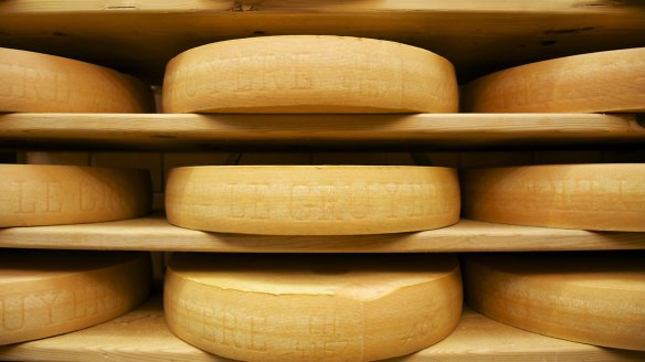 Wheels of Switzerland's most famous cheese matures on wooden shelves in Gruyeres.