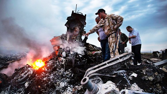 People inspect the crash site of Malaysia Airlines MH17. Russian propaganda 'trolls' have tweeted falsely that the Ukraine military shot the plane down.