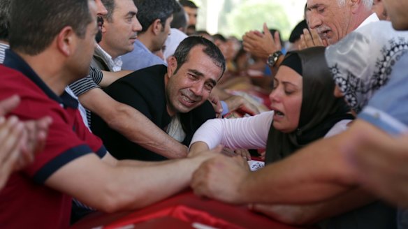 Relatives and friends mourn over the coffins of victims of the attack.