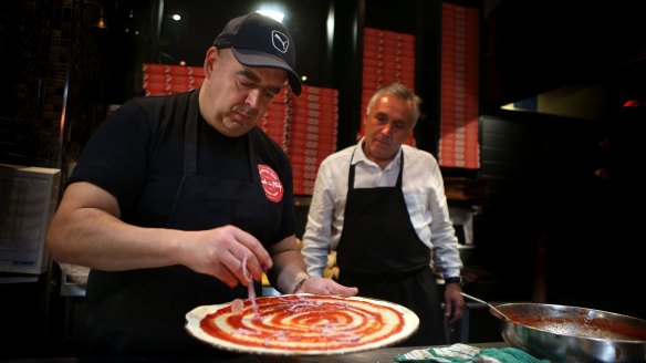 Sergio Checchi, co-owner of Made in Italy, watches chef Alesandro make a pizza. The eatery's joined the MealPal network.