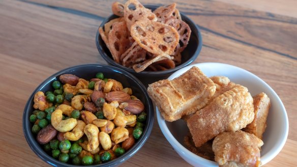 Trio of spiced snacks (clockwise from top) lotus chips, pork scratchings and nuts.