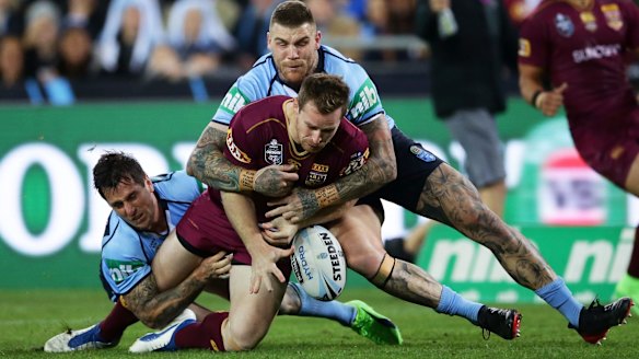 Solid defence: Michael Morgan of the Maroons drops the ball in a tackle by Mitchell Pearce and Josh Dugan.