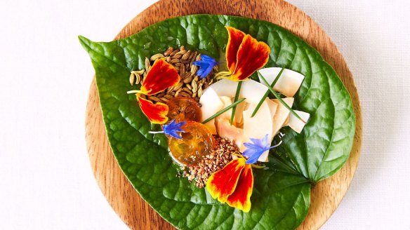 Enter Via Laundry's betel leaf topped with marigold, Geraldton wax and coconut.