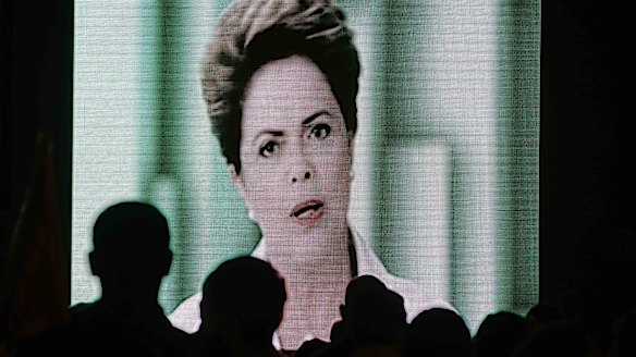 People watch a speech by Brazilian President Dilma Rousseff broadcast on the Workers Party's television program on Thursday evening.