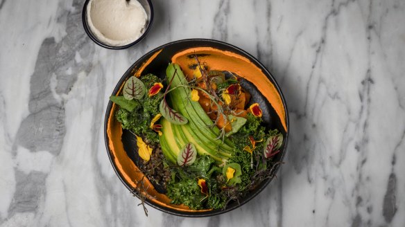 A plant bowl with quinoa, black lentils, pumpkin and preserved lemon tahini.