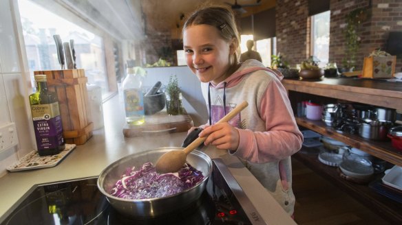 Josie Aberle cooks a meal on an induction cooker in Melbourne. Her parents chose not to connect their house to gas.
