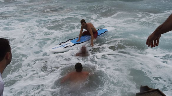 Lifeguards reached the man and paddled him to the beach.