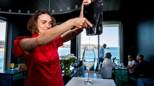  Sommelier Lillia McCabe pouring a glass of wine from bag to glass.