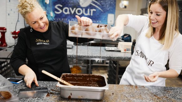 Kirsten Tibballs (left) and Anna Webster pouring chocolate into egg moulds.