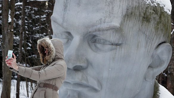 A woman takes a selfie with a statue of Lenin in a forest near Razliv Lake, outside St Petersburg.