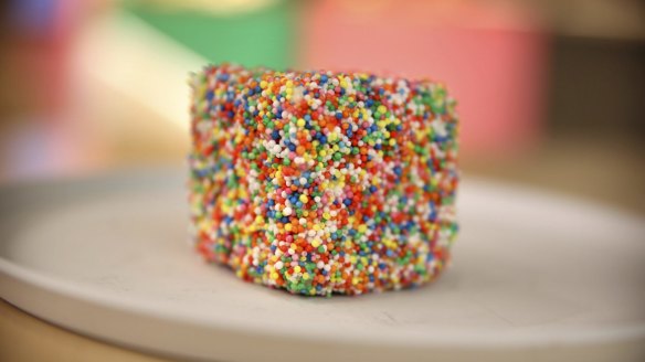 The fairy bread popcorn lamington is dunked in hundreds and thousands. 