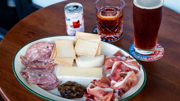 Negroni in a can, beer and a tasting cheese and meat plate.