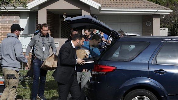 Detectives remove evidence from the Panania home of Moudasser Taleb on Thursday.