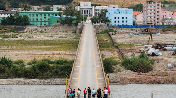 Chinese tourists stand on the Tumen bridge linking China and North Korea, as seen from Yanbian, China.