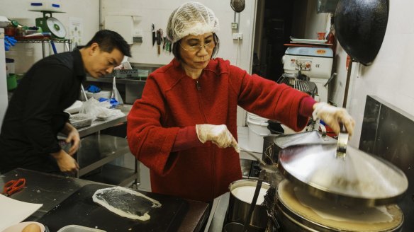 Anthony Dinh with his mother Kim Thanh making steamed rice paper rolls. 