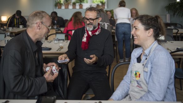 Massimo Bottura playing cards with diners at Refettorio Felix in London.