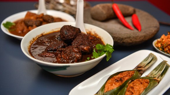 Babi pongteh (braised pork in fermented soy beans, left) and ayam keluak (chicken braised with keluak nuts, centre) are the restaurant's specialties.