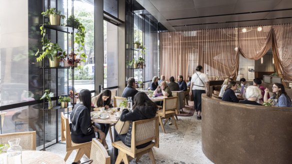 Tones are pink, brassy and timbered inside Dame in the light-filled Collins Place atrium.