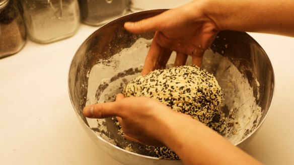 Coating the dough with seeds.