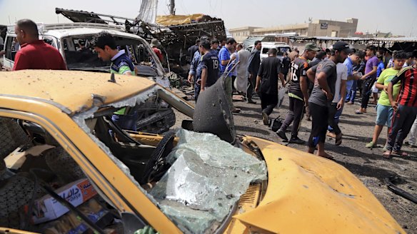 Citizens inspect the scene of a suicide car bomb which hit a crowded outdoor market in Baghdad's eastern Shiite neighborhood of Sadr City on Tuesday.