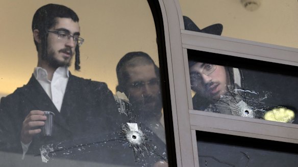 Jewish religious students examine bullet holes in the aftermath of the Har Nof synagogue attack in Jerusalem.