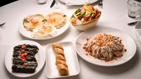 Banquet dishes clockwise from top left: Mixed dips, fattoush salad, chicken and rice topped with almonds, baklava and silverbeet rolls.