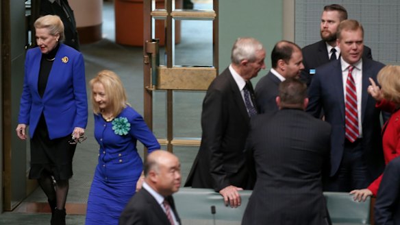 Former speaker Bronwyn Bishop enters the chamber while Tony Smith is congratulated by colleagues in the House of Representatives following his selection as her replacement.