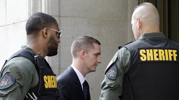 Officer Edward Nero, centre, one of six Baltimore city police officers charged in connection to the death of Freddie Gray, arrives at a courthouse to receive a verdict in his trial in Baltimore on Monday. 
