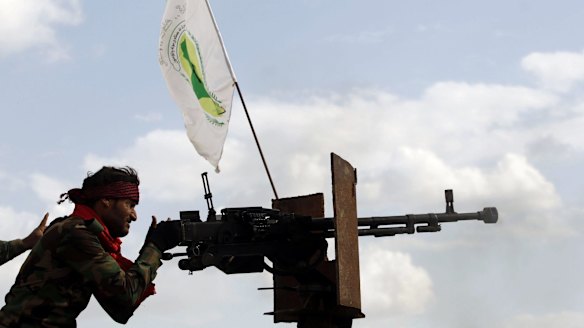 A Shiite militiaman fires a weapon during clashes with IS in Iraq.