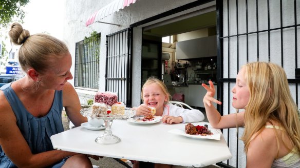 Ruby, 8, and Millie, 5, with mother Cara Renshaw enjoy a lamington from Luscious Kiki Cakes in Brookvale. 